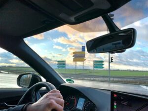 Das Autofahren. Fotografie aus vom Beifahrersitz in einem Audi Q1 an einer Fernstraßenkreuzung und Abfahrt von einer Bundesautobahn