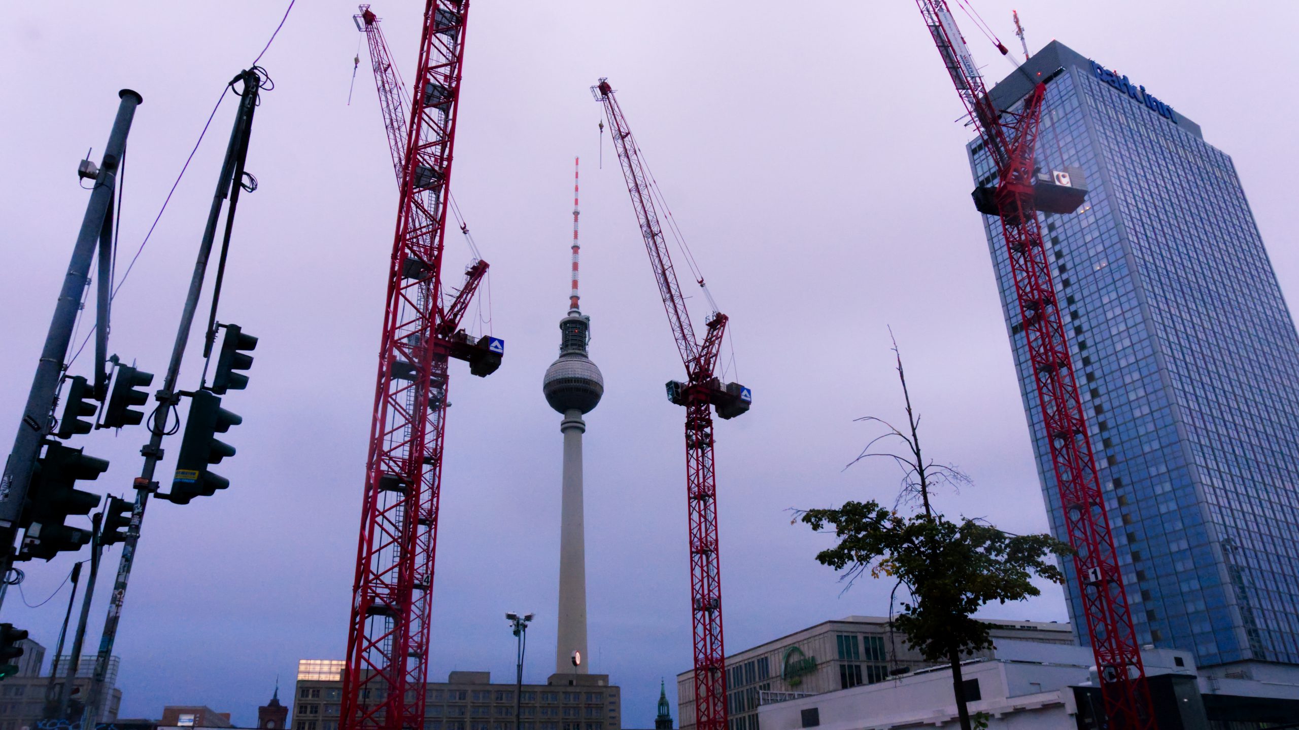 Berliner Fernsehturm am Alexanderplatz gerahmt von Baukrähnen und dem Park-Inn Hotel © Patrick Pehl