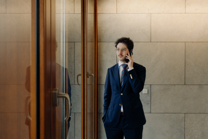 Patrick Pehl ist immer an neuer Sachpolitik interessiert und telefoniert am Fenster im Jakob-Kaiser-Haus, einer Liegenschaft des Bundestages, in Berlin. Pehl trägt einen blauen Anzug mit Nadelstreifen und eine bunt gestreifte Seidenkrawatte.