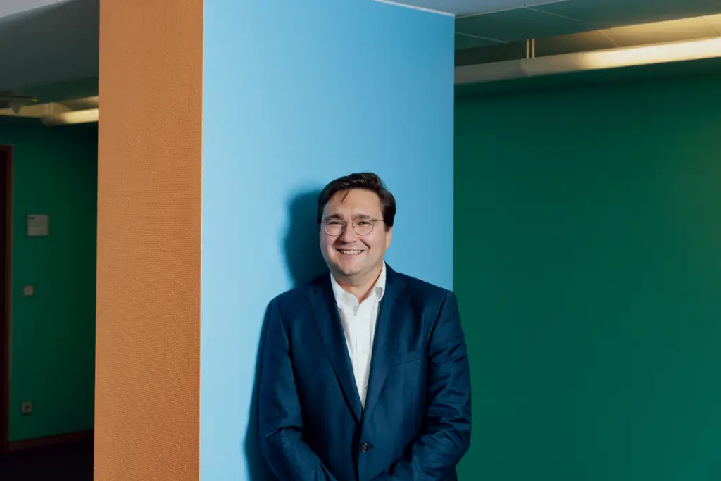 Christian Moser im Matthias-Erzberger-Haus (Unter den Linden 71) vor einem Pfeiler an bunter Wand