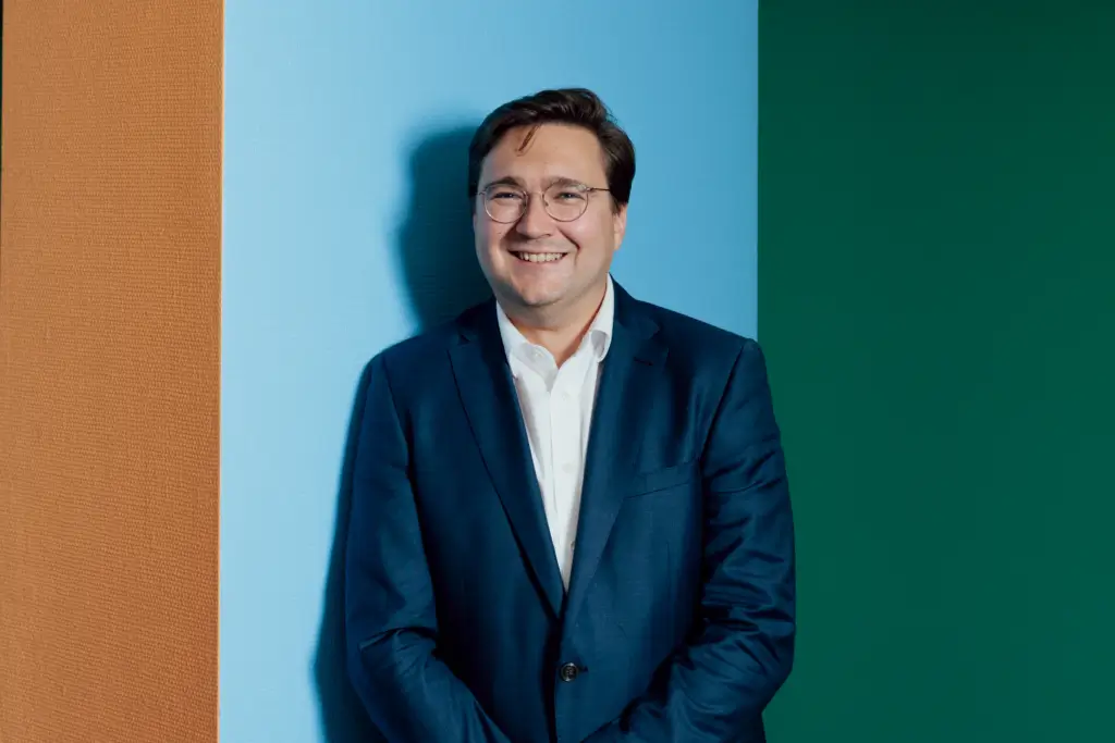 Christian Moser im Matthias-Erzberger-Haus (Unter den Linden 71) vor einem Pfeiler an bunter Wand