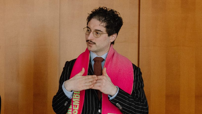 Patrick Pehl mit Fanschal des Berliner Ensemble bei einem Interview im Bundestag
